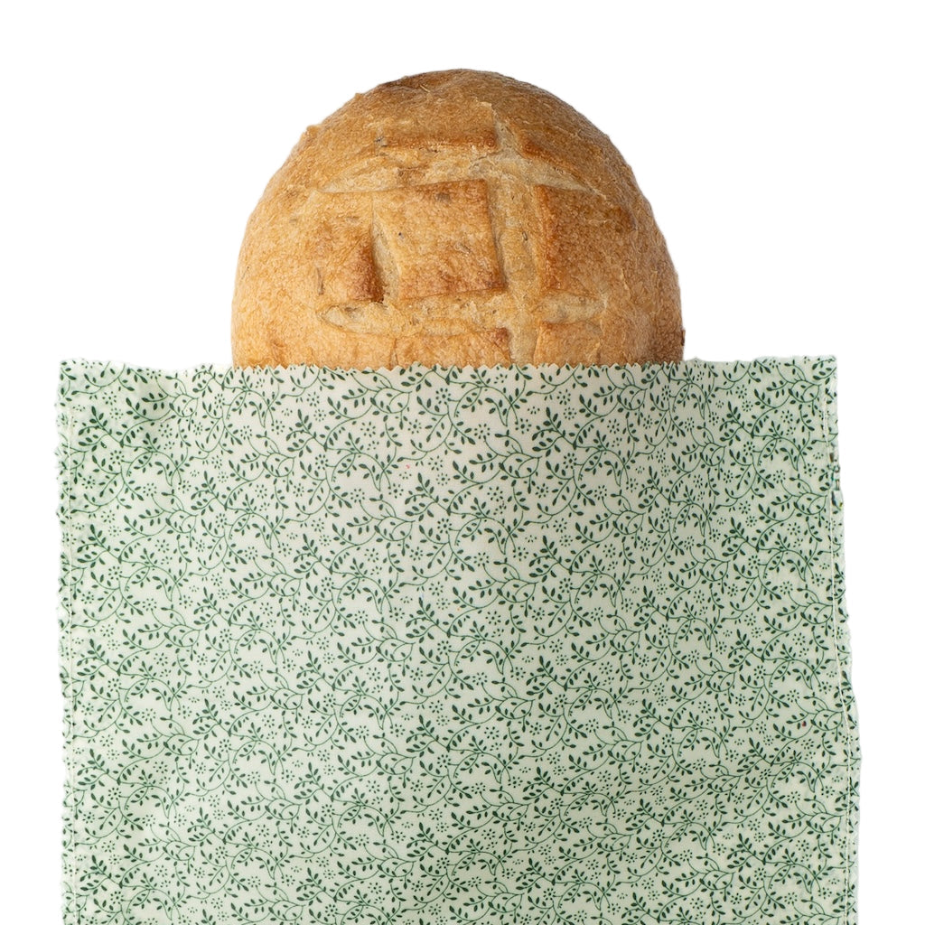 Loaf of bread on a green speckled surface with a white background